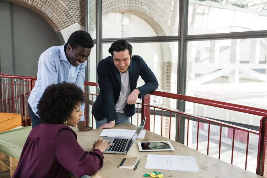 mm lite
grupo de tres personas viendo un computador, en una oficina