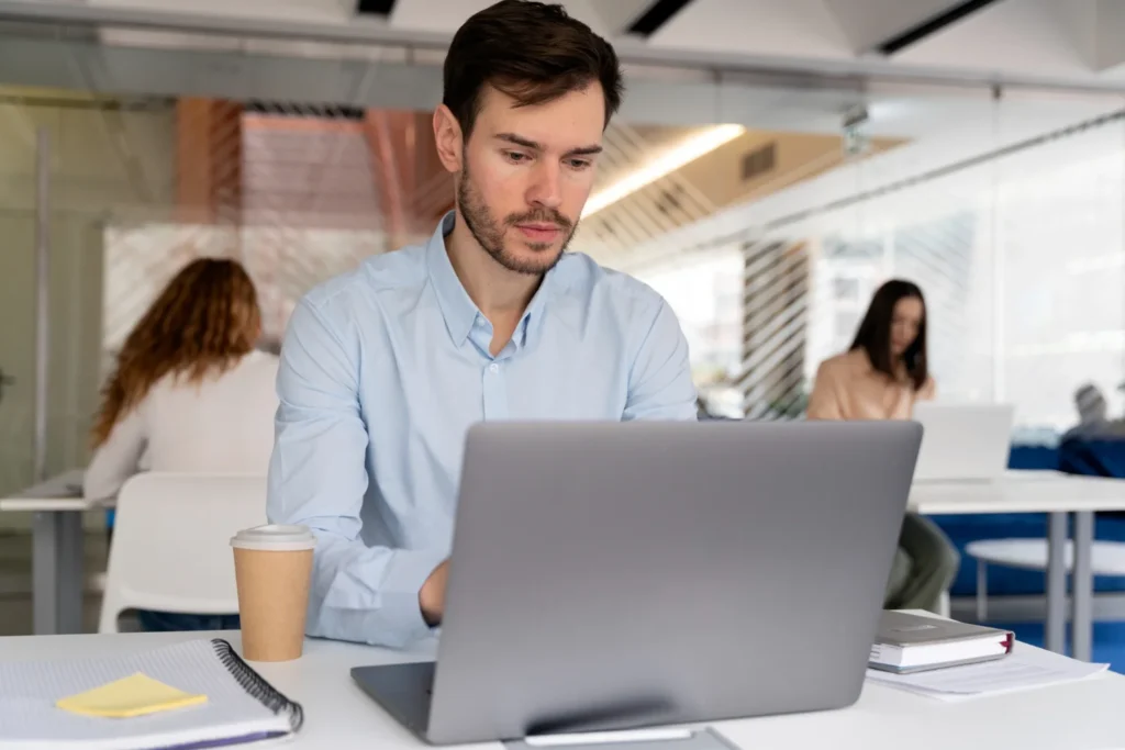 persona leyendo la documentación de las políticas internas de la empresa, en la mesa de una oficina desde el computador